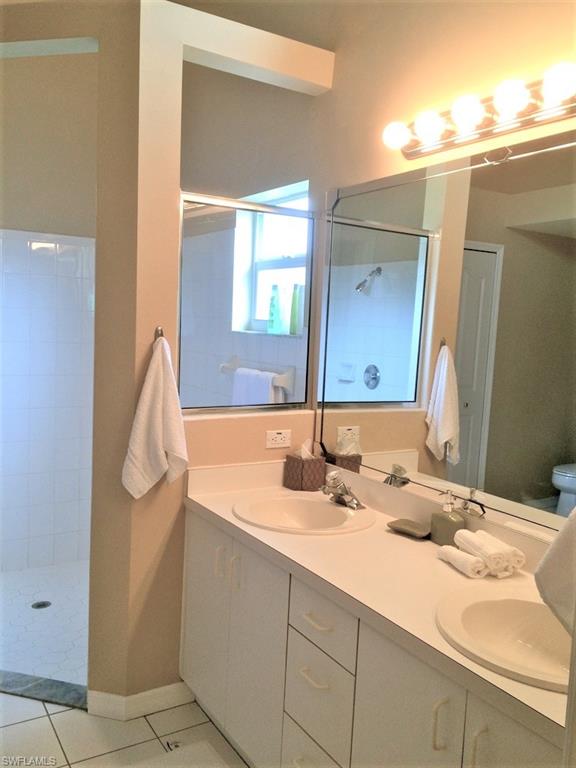 2258 Stacil Circle, Unit 1 Naples, FL 34109 - Photo 18 of 28 a bathroom with a sink and a mirror