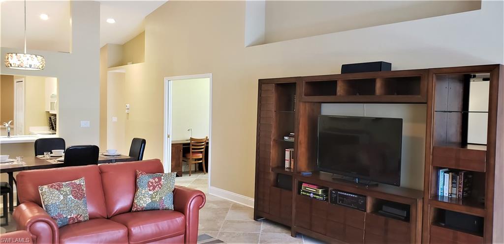 2258 Stacil Circle, Unit 1 Naples, FL 34109 - Photo 6 of 28 a living room with furniture a flat screen tv and a fireplace