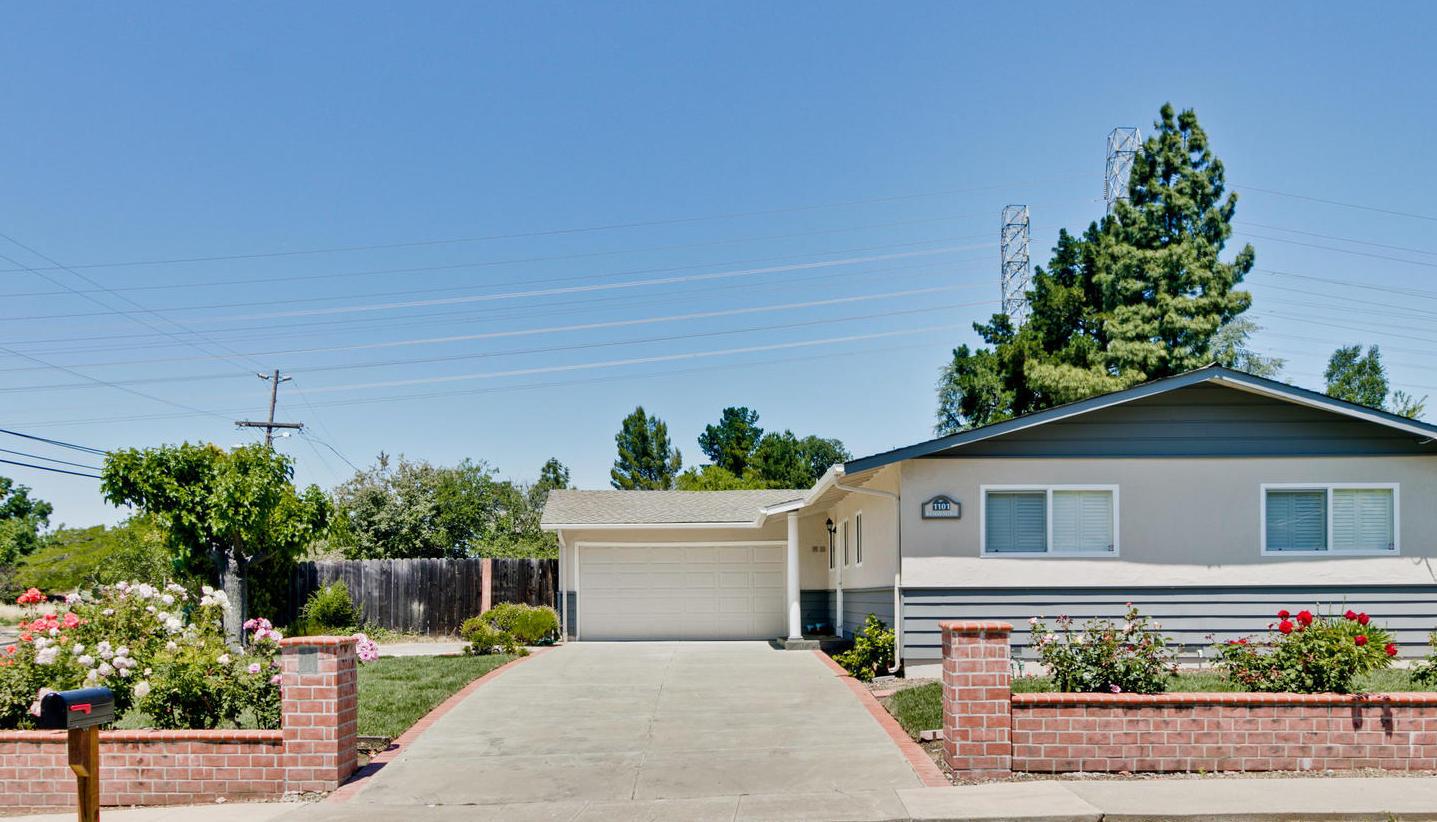 1101 Kenwal Road Concord, CA 94521 - Photo 2 of 20 a white house with flower garden in front of it