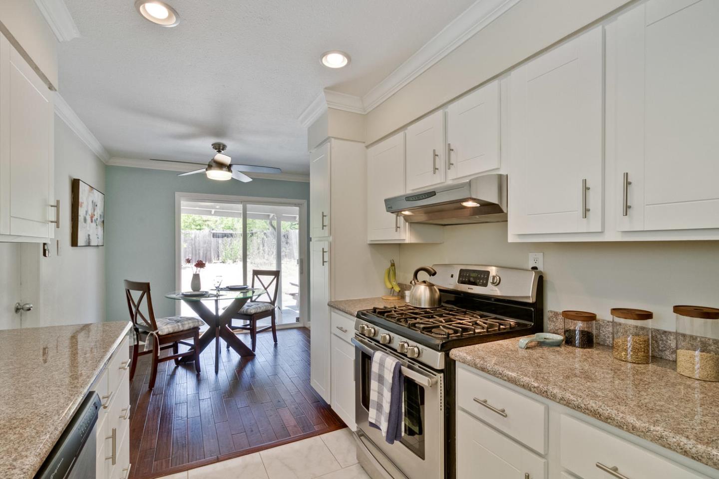 1101 Kenwal Road Concord, CA 94521 - Photo 10 of 20 a kitchen with granite countertop a stove a sink a dining table and chairs with wooden floor