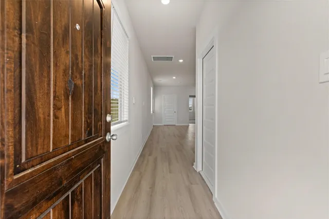 a view of a hallway with wooden floor