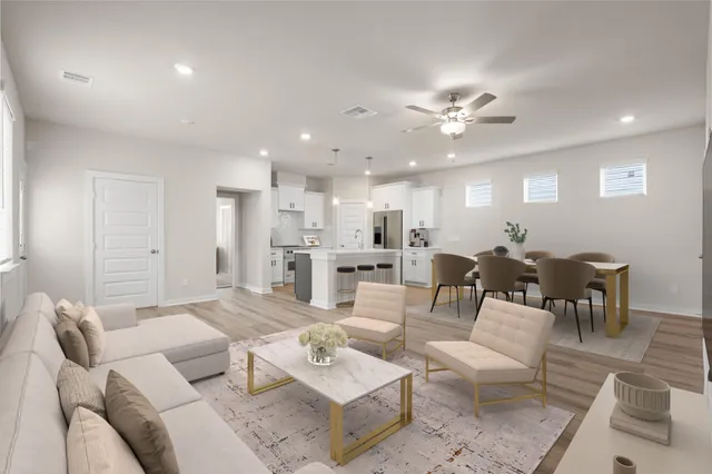 a living room with lots of furniture and view of kitchen