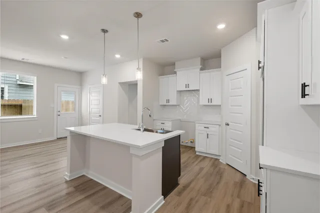 a kitchen with a sink stove and cabinets