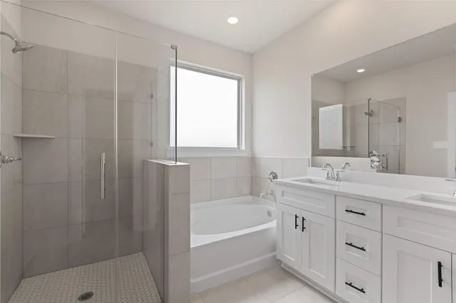 a bathroom with a tub sink shower and two mirror