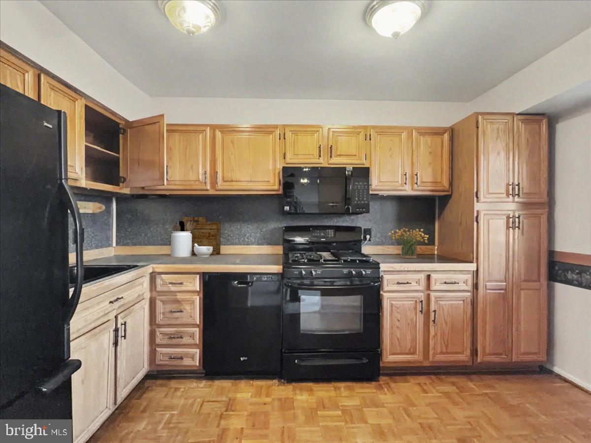 1575 Creekside Road, Unit A21 Whitehall, PA 18052 - Photo 4 of 21 a kitchen with stainless steel appliances granite countertop a stove top oven a sink dishwasher and a refrigerator with wooden cabinets