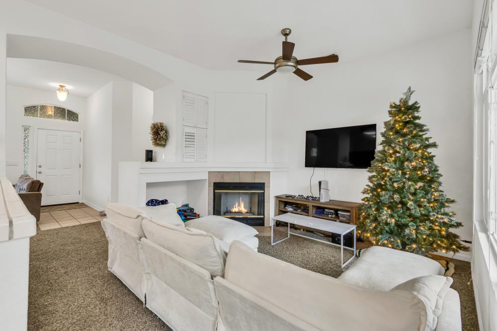 8679 Spring House Way Elk Grove, CA 95624 - Photo 12 of 48 a living room with furniture a fireplace and a flat screen tv