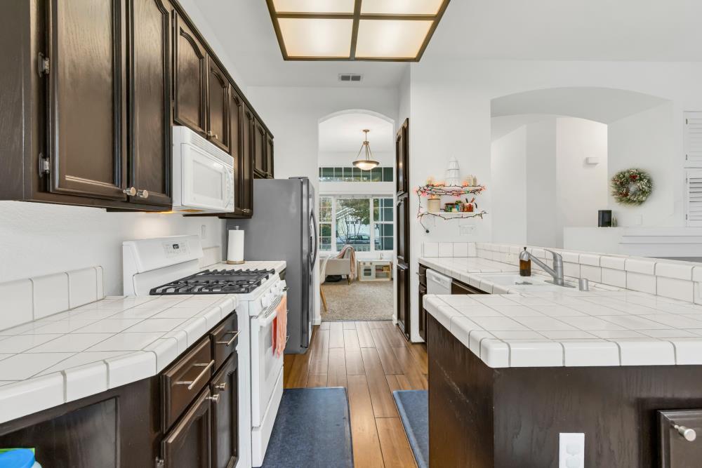 8679 Spring House Way Elk Grove, CA 95624 - Photo 17 of 48 a kitchen with counter top space a sink stove and refrigerator