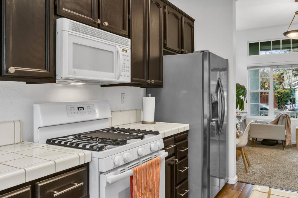8679 Spring House Way Elk Grove, CA 95624 - Photo 18 of 48 a kitchen with stainless steel appliances granite countertop a stove a refrigerator and a microwave
