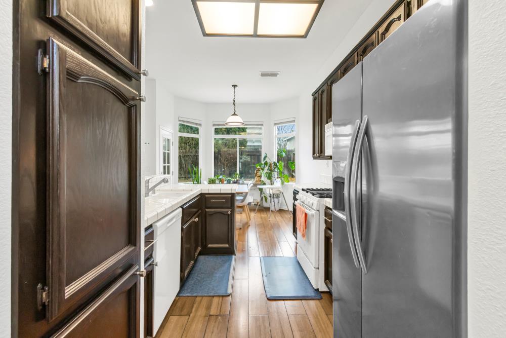 8679 Spring House Way Elk Grove, CA 95624 - Photo 20 of 48 an empty room with wooden floor and stainless steel appliances