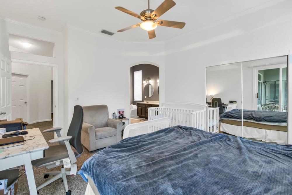 8679 Spring House Way Elk Grove, CA 95624 - Photo 32 of 48 a bedroom with a bed and a chandelier