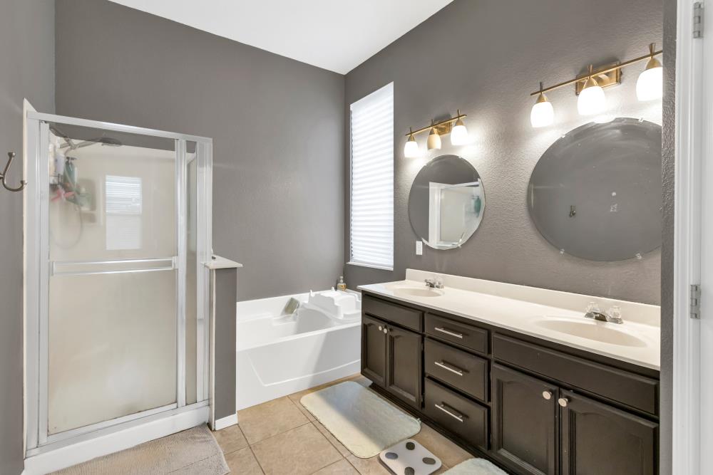 8679 Spring House Way Elk Grove, CA 95624 - Photo 33 of 48 a bathroom with a double vanity sink mirror and bathtub