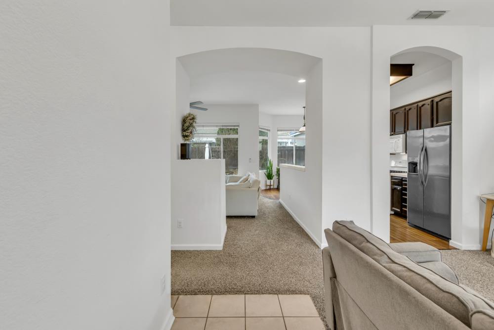 8679 Spring House Way Elk Grove, CA 95624 - Photo 6 of 48 a living room with stainless steel appliances furniture a rug and a kitchen view
