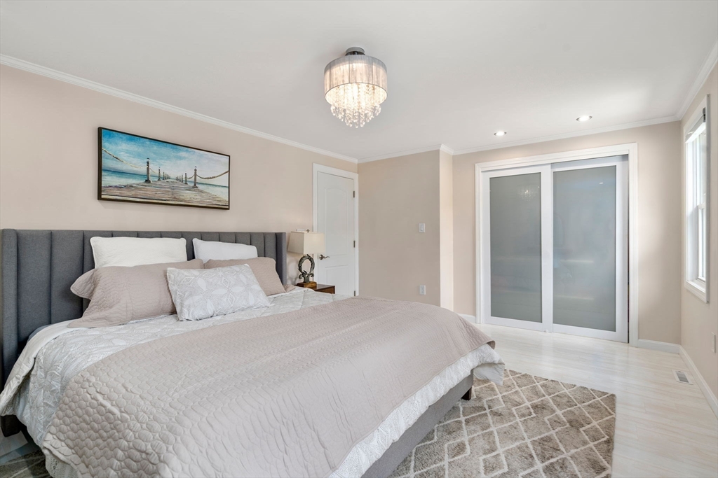 149 Bolivar Street, Unit C6 Canton, MA 02021 - Photo 24 of 41 a bedroom with a large bed and a chandelier