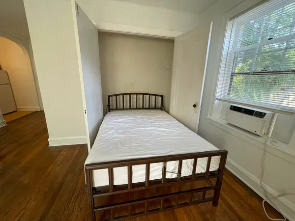 a bedroom with a bed and wooden floor