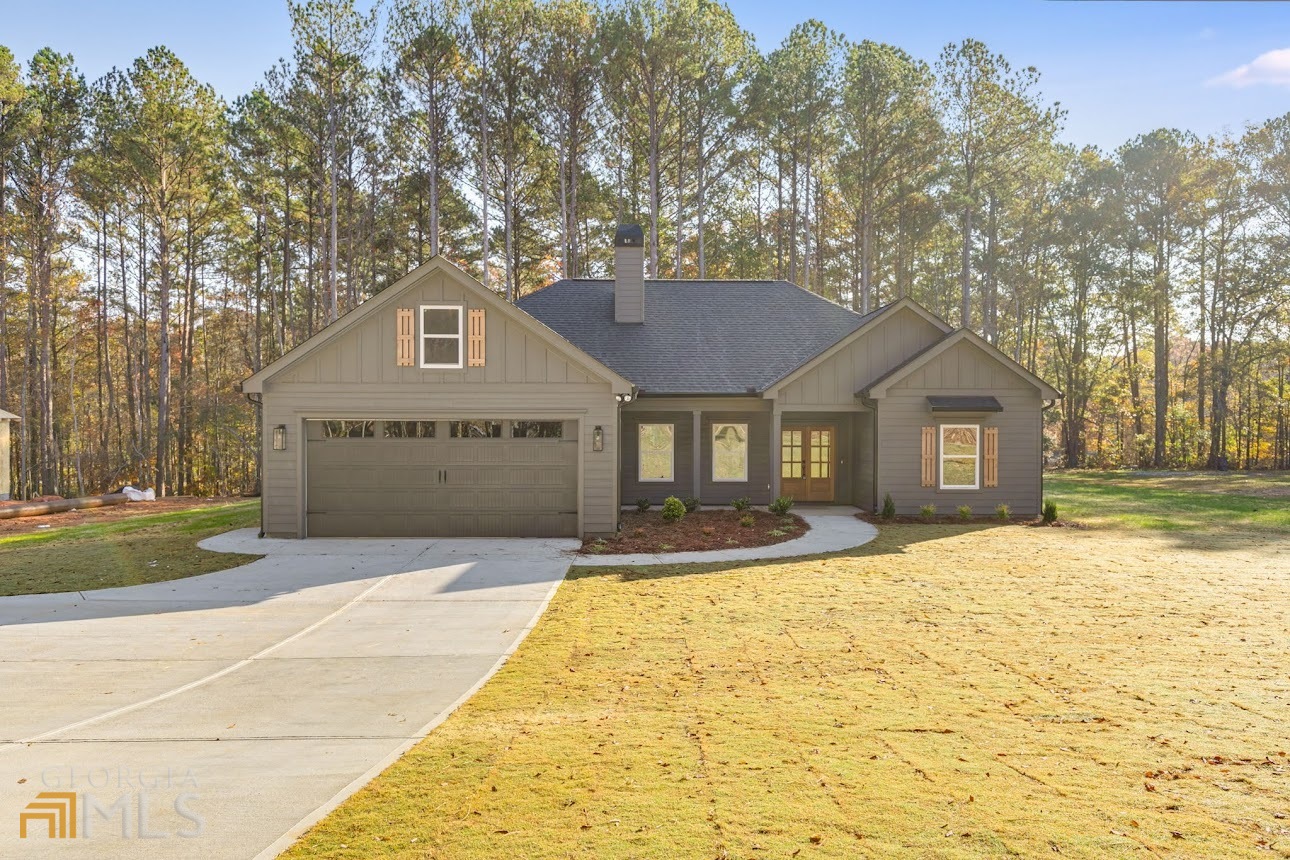 a front view of a house with a yard and trees