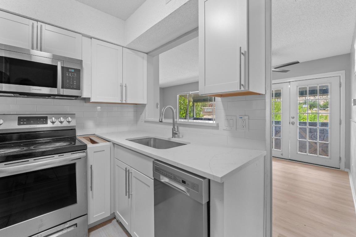 8903 Parkfield Drive, Unit 203 Austin, TX 78758 - Photo 1 of 11 a kitchen with a stove microwave and sink