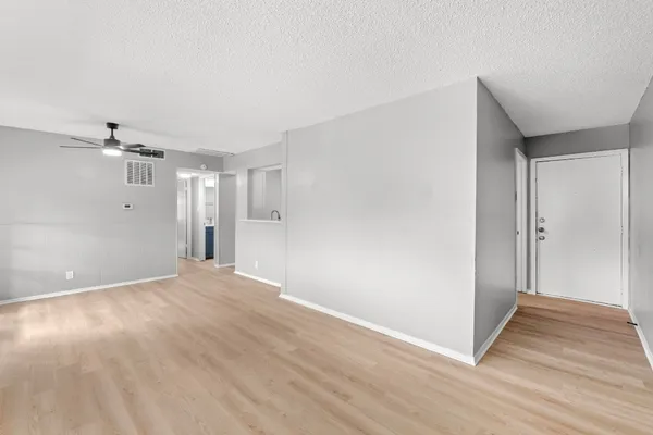 a view of a big room with wooden floor and windows