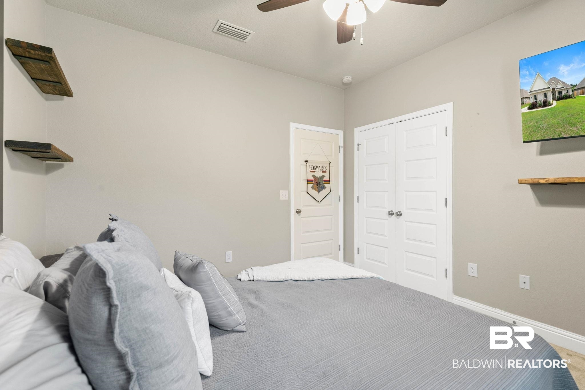 31187 Spoonbill Road Daphne, AL 36527 - Photo 41 of 85 Neutral-toned interior room featuring wood-finish ceiling fan, wood-finish wall shelving, white paneled doors, and light-colored walls
