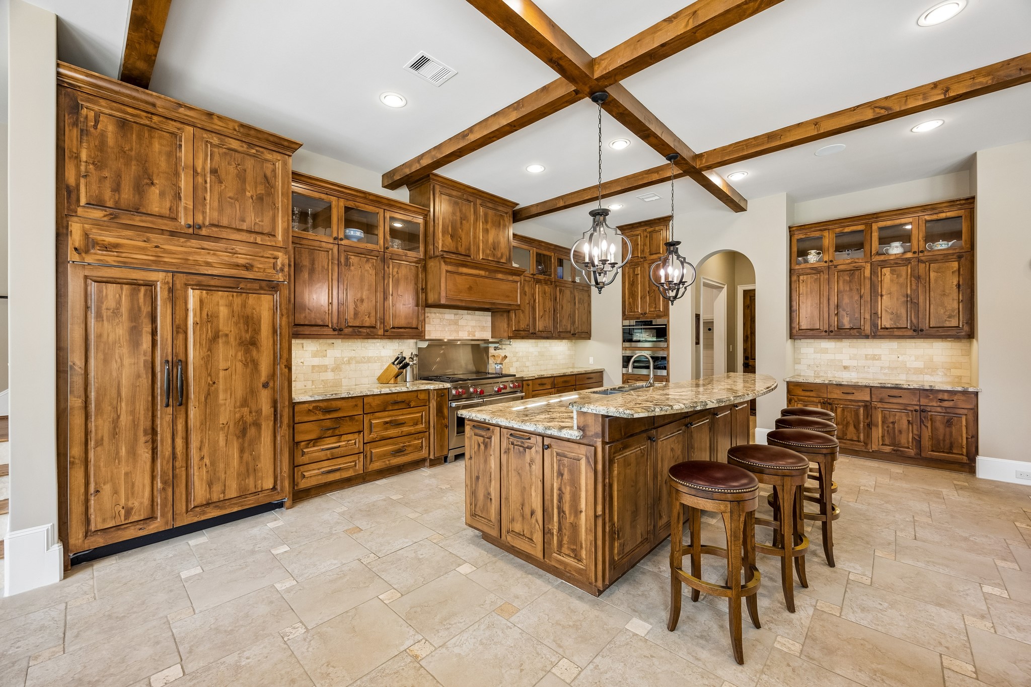 13127 Highwood Road Houston, TX 77079 - Photo 4 of 33 The heart of the home is this spectacular chef's kitchen, showcasing an oversized island, custom alder cabinetry, and a complete Wolf & Sub-Zero appliance package, including a Wolf steam oven. Designed for both everyday living and effortless entertaining, it offers exceptional craftsmanship, abundant storage, and timeless luxury.