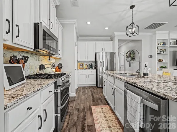 a kitchen with stainless steel appliances granite countertop a stove and a sink