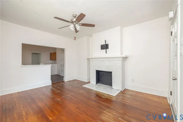 a view of a livingroom with wooden floor and a ceiling fan