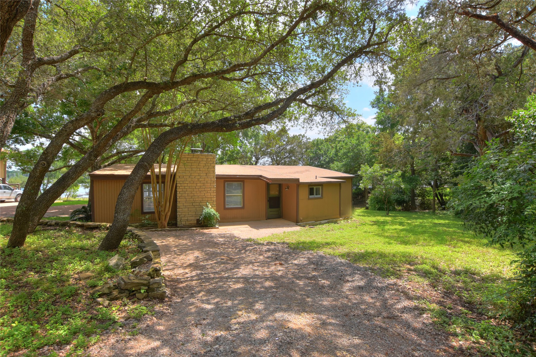 View of front of house featuring a chimney, a front yard, and driveway