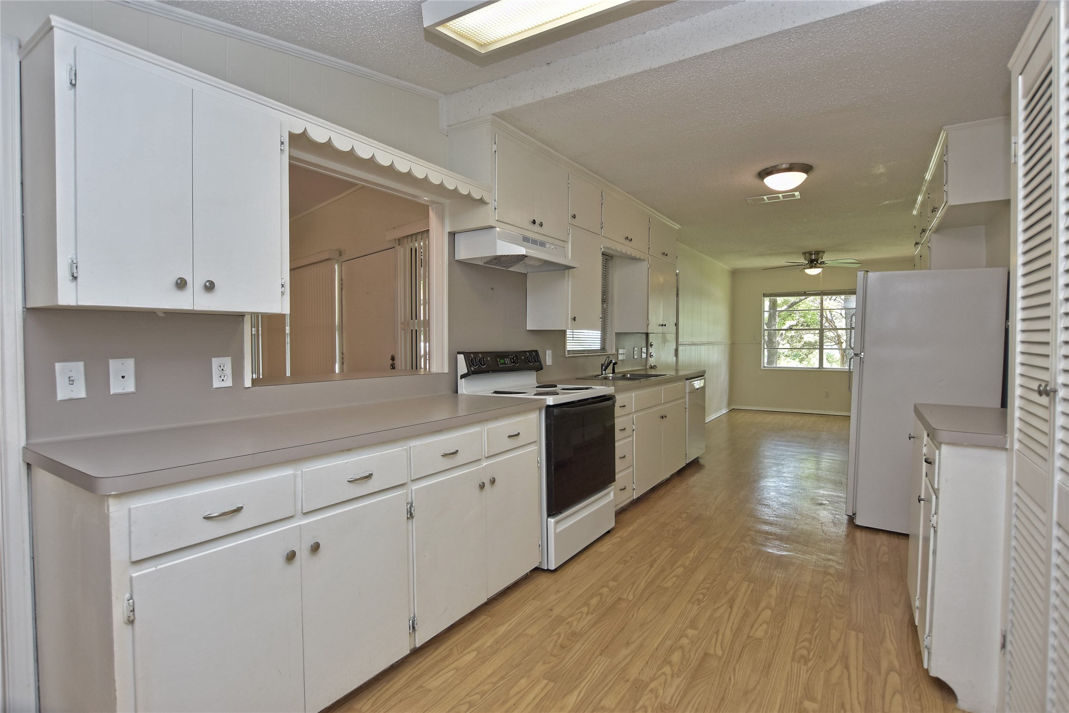 16013 Edwards Drive Austin, TX 78734 - Photo 13 of 30 Kitchen with white appliances, a textured ceiling, light countertops, and white cabinets