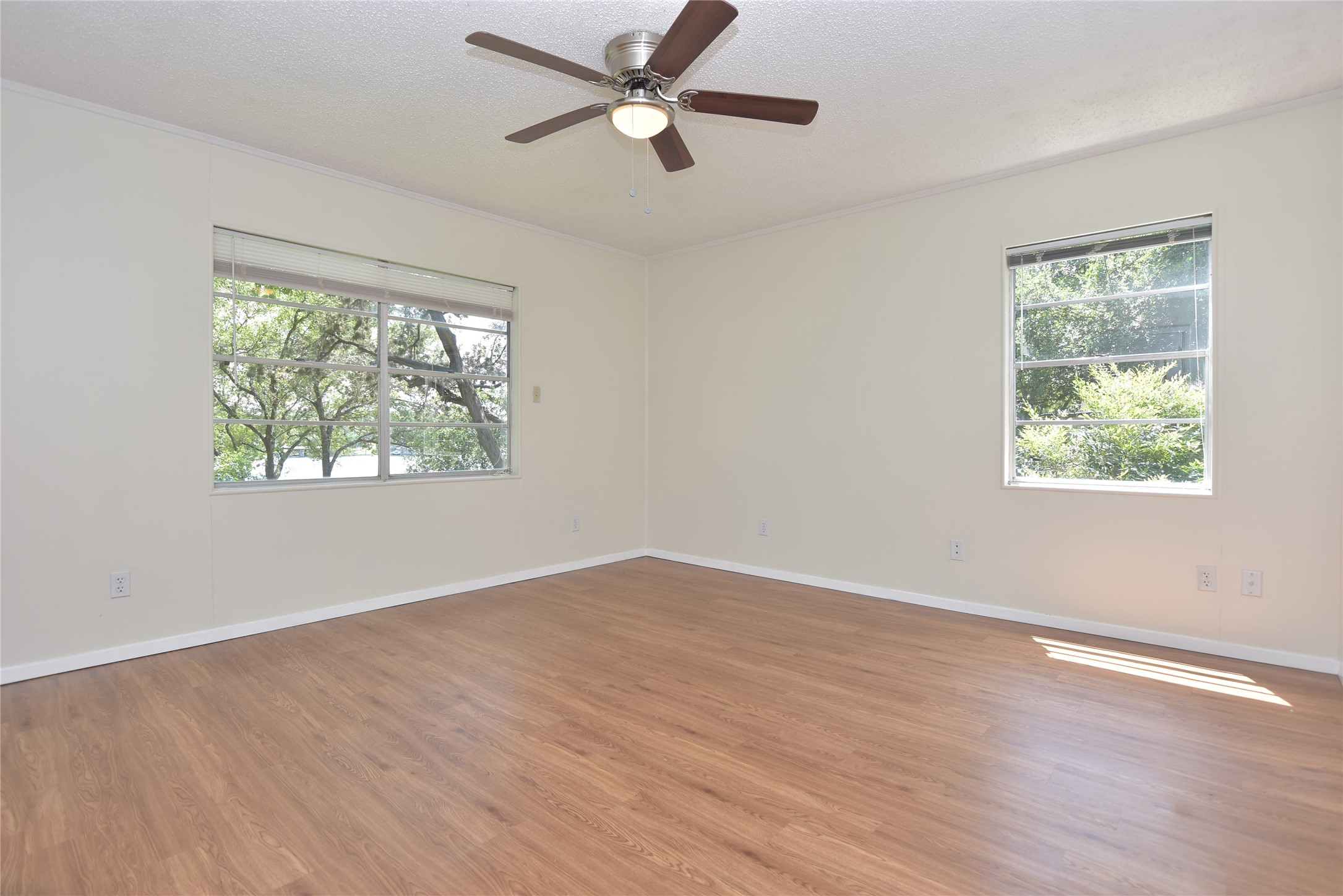 16013 Edwards Drive Austin, TX 78734 - Photo 15 of 30 Unfurnished room featuring dark wood-type flooring, a ceiling fan, a textured ceiling, and crown molding