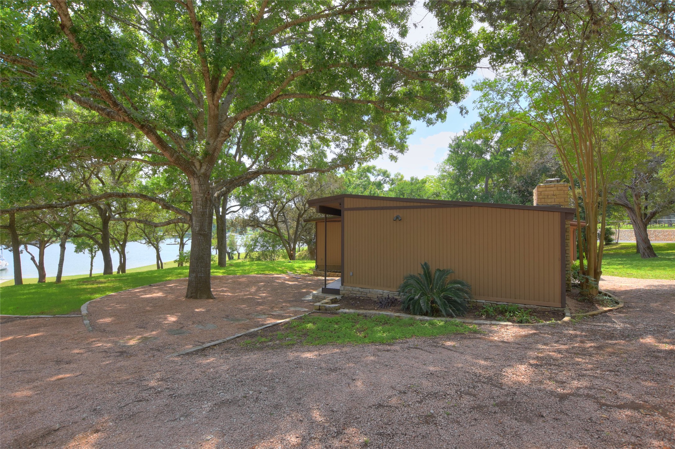 16013 Edwards Drive Austin, TX 78734 - Photo 28 of 30 View of side of home with an outbuilding, a pole building, and a chimney