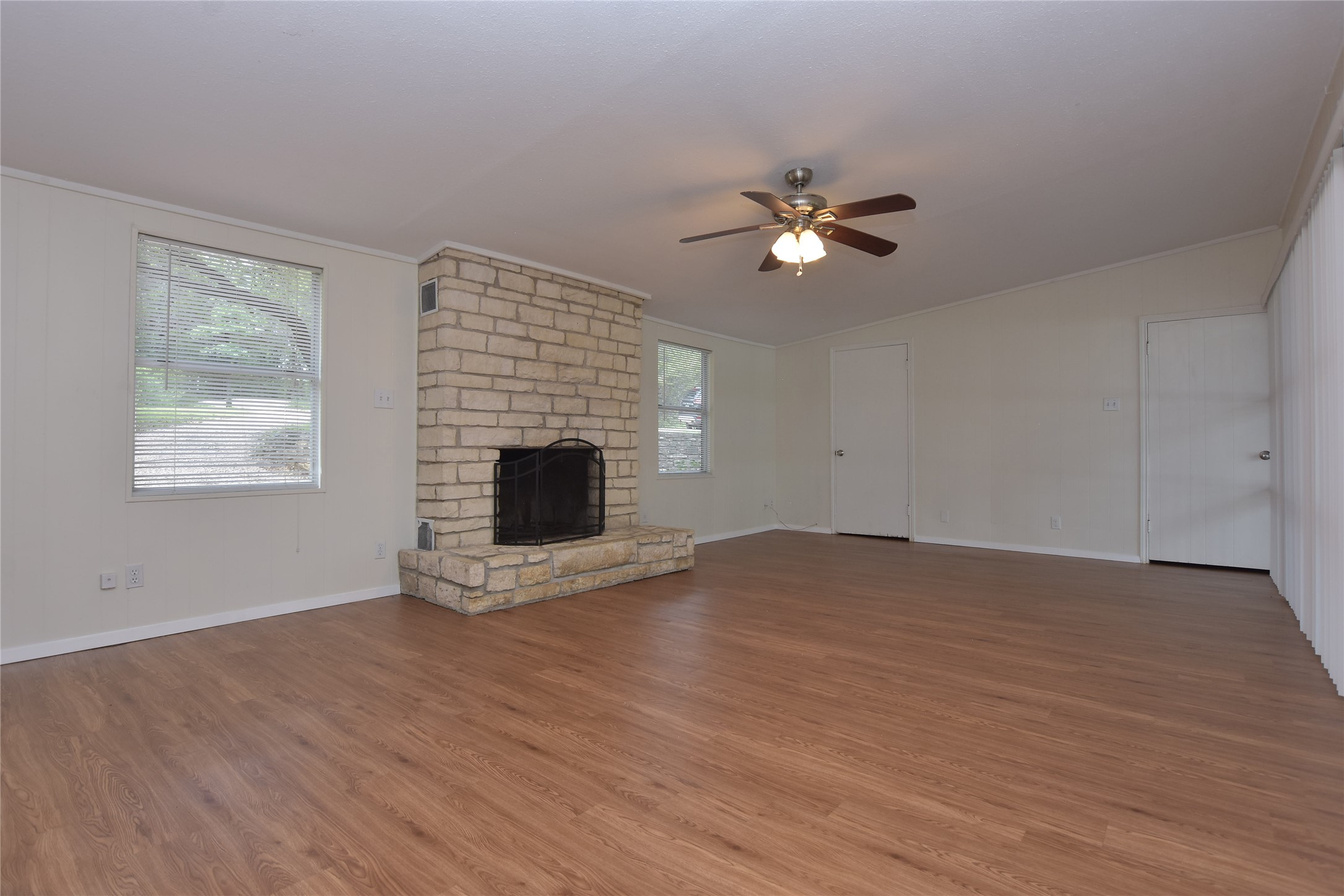 16013 Edwards Drive Austin, TX 78734 - Photo 6 of 30 Unfurnished living room featuring a large fireplace, ornamental molding, ceiling fan, wood finished floors, and lofted ceiling