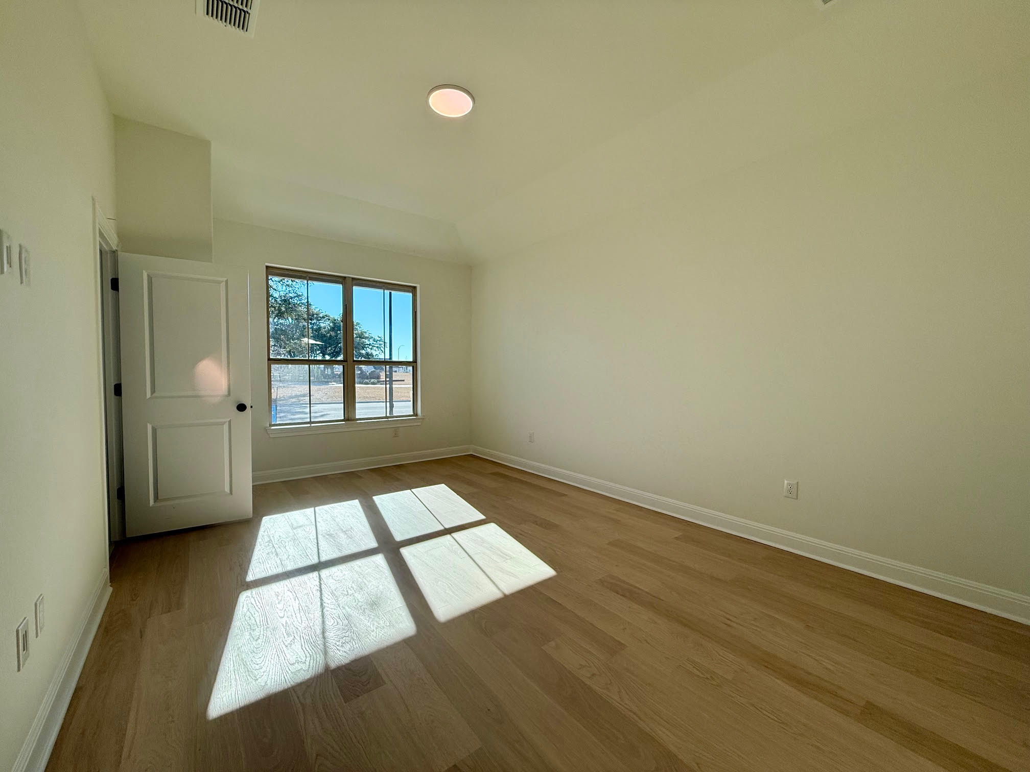 332 Glocken Lane Kyle, TX 78640 - Photo 12 of 27 an empty room with wooden floor and windows