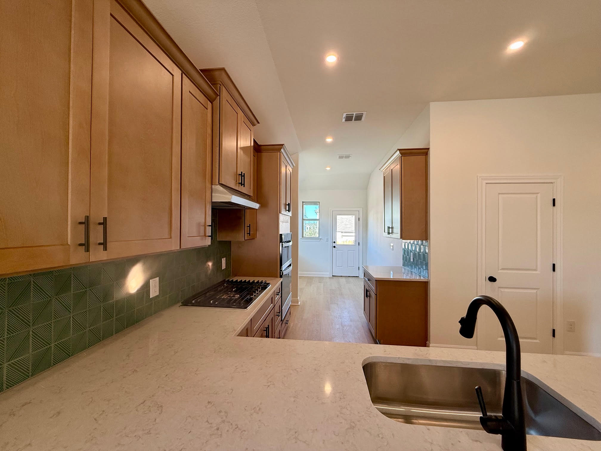 332 Glocken Lane Kyle, TX 78640 - Photo 7 of 27 a kitchen with granite countertop a stove and white cabinets with wooden floor