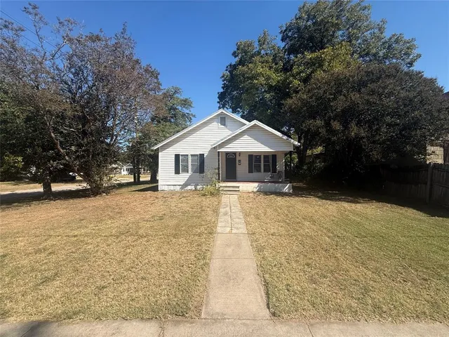 a front view of house with yard and trees around