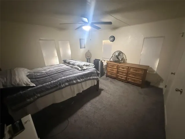 a bedroom with a bed and a lamp on dresser