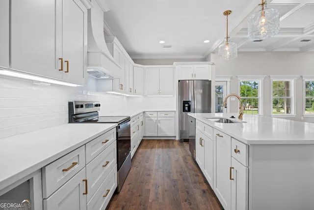 a kitchen with cabinets a sink dishwasher a refrigerator and a stove with wooden floor