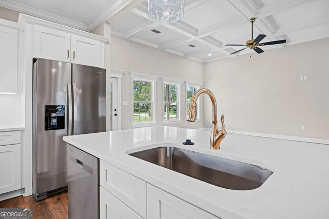 a kitchen with stainless steel appliances granite countertop a sink a refrigerator and a sink