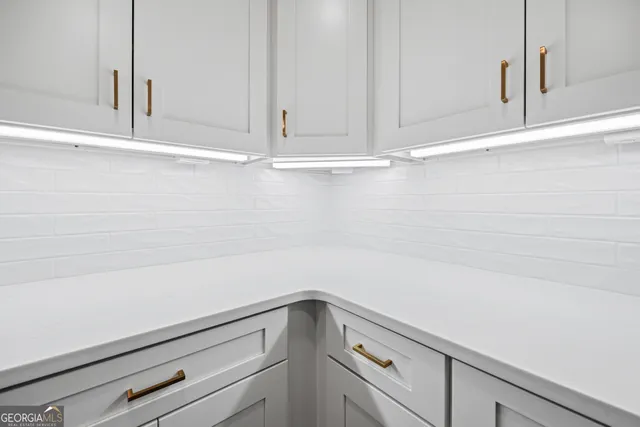 a view of a kitchen with white cabinets