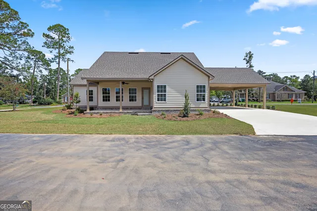 a view of house with a yard and potted plants