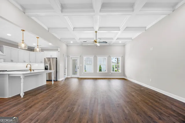 a view of an empty room with window and wooden floor