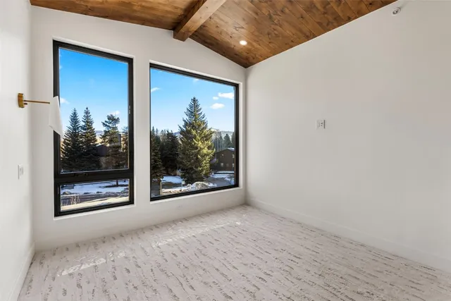 a view of a room with wooden floor and a floor to ceiling window