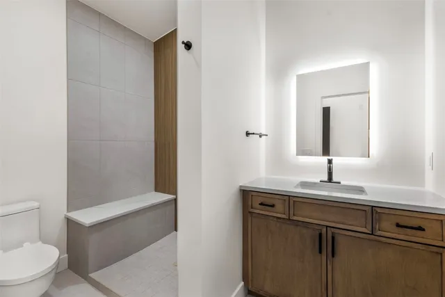 a bathroom with a sink a toilet and shower