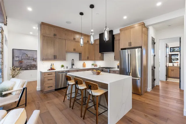 a large kitchen with a table chairs refrigerator and microwave