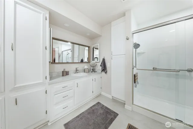 a bathroom with a sink a mirror and a shower