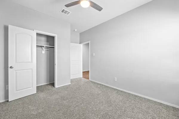 a view of an empty room with a ceiling fan