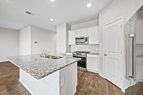 a kitchen with stainless steel appliances granite countertop a sink stove and refrigerator