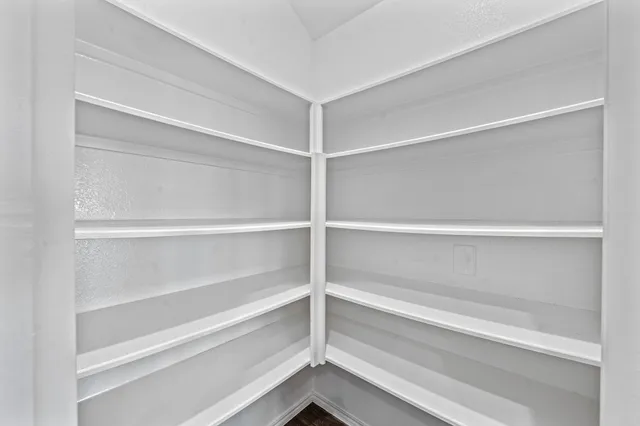 a view of walk in closet with empty racks