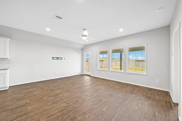 a view of kitchen with granite countertop cabinets and refrigerator