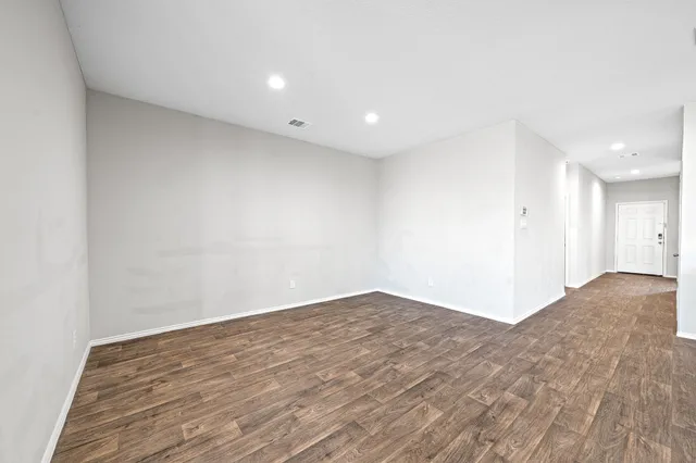 a view of kitchen with kitchen island wooden floors granite counter tops and white stainless steel appliances