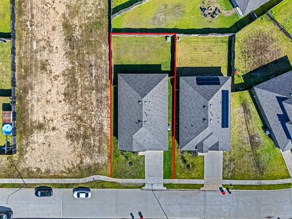 an aerial view of a brick house with a yard