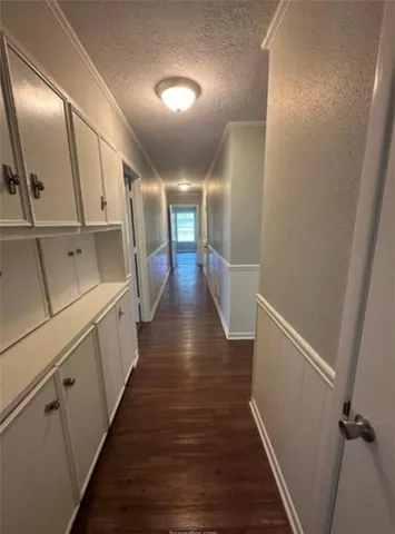 a hallway with wooden floor and staircase